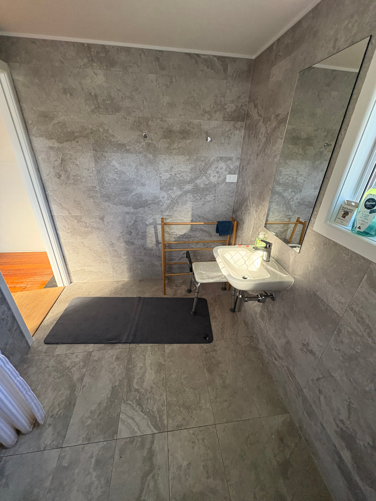 Renovated bathroom with wall-hung vanity and large-format tiles