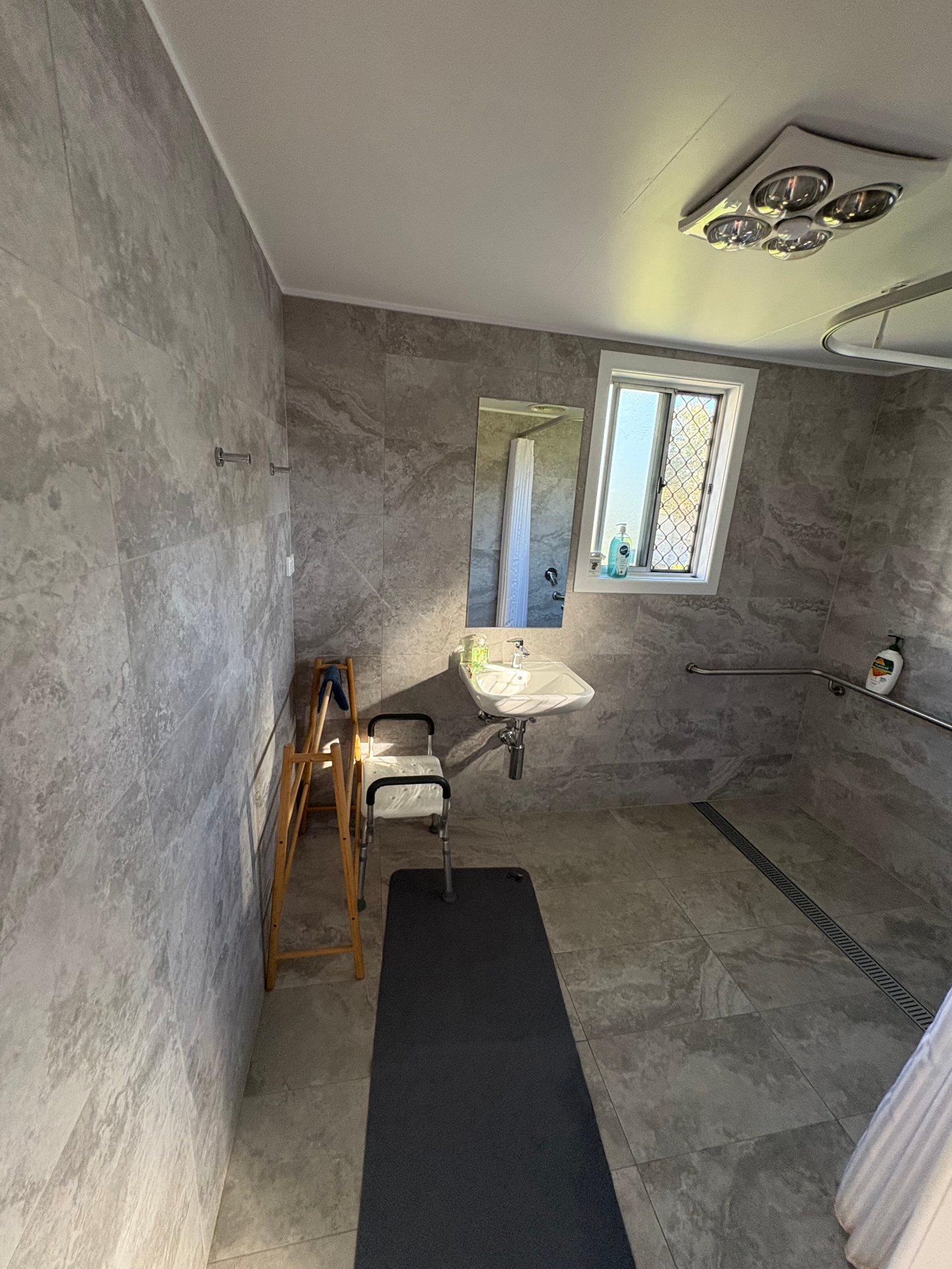 Spacious accessible bathroom with shower seat and grab rails